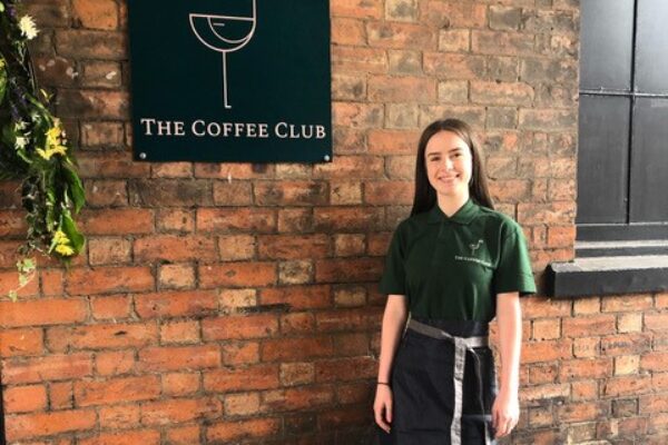 Coffee Club staff member standing outside the entrance